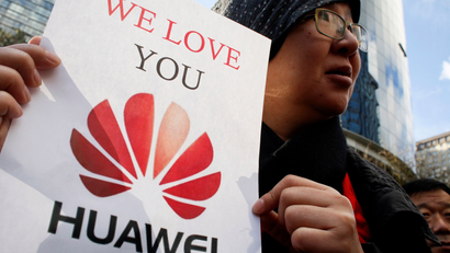 a visitor from China, holds a sign in support of Huawei outside of the B.C. Supreme Court bail hearing of Huawei CFO Meng Wanzhou, who is being held on an extradition warrant in Vancouver, British Columbia, Canada December 10, 2018. REUTERS/David Ryder/File Photo - RC179918A790