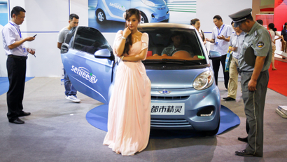 epa03294095 A model stands next to a Chinese made Senlee electric vehicle at the 8th Beijing International Pure Electric Vehicles, Hybrid Electric Vehicles and Charging Station Exhibition in Beijing, China 03 July 2012. The expo opened on 03 July and will run until 05 July. EPA/DIEGO AZUBEL
