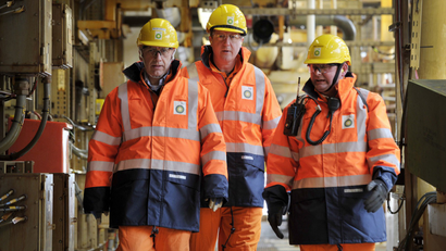 Britain's Prime Minister David Cameron (C) walks with BP regional president North Sea Trevor Garlick