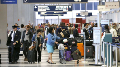 Passengers at O'Hare International Airport wait in a ticketing line Tuesday, May 13, 2014, in Chicago. Smoke in a regional radar facility forced a halt to all incoming and outgoing flights at both of Chicago’s airports. The Federal Aviation Administration says all its personnel were evacuated from the Chicago Terminal Radar Approach Control, or TRACON, facility in suburban Elgin at around 11:30 a.m. Tuesday.(AP Photo/Charles Rex Arbogast)
