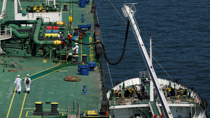 A bunker fuel ship pulls up next to a cargo vessel to refuel.