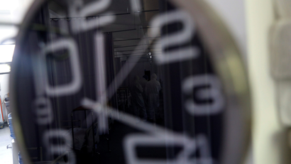 Medical staff are seen reflected on a clock inside a hospital in Mexico.