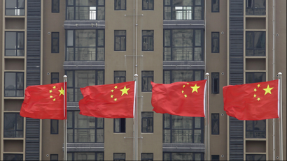 Chinese national flags fly in front of a newly-built residential apartment in Wuhan, Hubei province July 10, 2012. China must firmly maintain its property tightening measures to cool housing prices, Premier Wen Jiabao was quoted as saying on Saturday, underscoring official concerns about renewed bubbles as the central bank ratchets up policy easing to support growth. REUTERS/Stringer