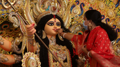 A woman offers sweets to an idol of the Hindu goddess Durga while offering prayers on the last day of the Durga Puja festival in Kolkata