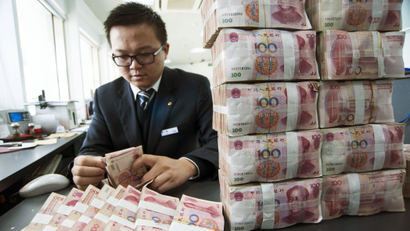 A clerk counts Chinese 100 yuan banknotes at a branch of China Construction Bank in Nantong, Jiangsu province December 2, 2014. China stocks leapt on Tuesday, as a mainland rally gained fresh steam, with investors pouring into brokerages and banking shares, widening the valuation gap with Hong Kong shares. Bank of China Ltd, Agricultural Bank of China Ltd and China Construction Bank Corp were all up close to 5 percent in late afternoon trading.
