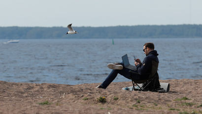 man working with laptop on a beach
