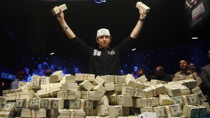 A poker player in front a pile of cash.