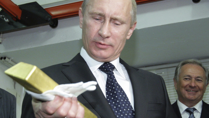 Russian Prime Minister Vladimir Putin holds a gold bar while visiting the Central Bank depositary in Moscow, Monday, Jan. 24, 2011.