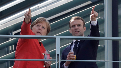 French President Emmanuel Macron, right, and German Chancellor Angela Merkel take a break on a balcony of Merkel's office.