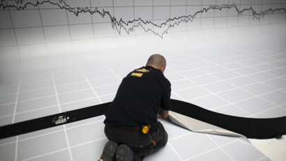 DATE IMPORTED:May 17, 2012A graph is seen above a worker as he puts the finishing touches to a stage decoration for an investment funds awards dinner at the Madrid stock exchange May 17, 2012. Spain's benchmark IBEX index fell nearly 2 percent to its lowest level since mid-2003, as shares in Bankia slumped following a report in the El Mundo newspaper that its customers had withdrawn more than 1 billion euros from their accounts over the past week. REUTERS/Paul Hanna (SPAIN - Tags: BUSINESS POLITICS TPX IMAGES OF THE DAY)