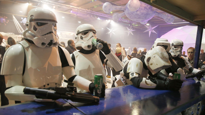 People dressed as Storm troopers stand at a bar as they pose for a photograph holding cans of beer at the 'For The Love of The Force' Star Wars fan convention in Manchester, northern England, December 4, 2015.