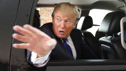 Donald Trump waves as he leaves a Greater Nashua Chamber of Commerce business expo at the Radisson Hotel in Nashua