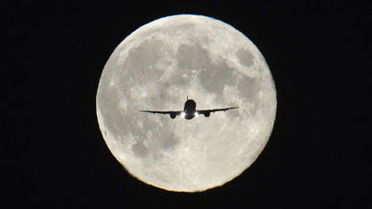 A passenger aircraft, with the full "Harvest Moon" seen behind, makes its final approach to landing at Heathrow Airport in west London, September 19, 2013. The Harvest Moon is a traditional name for the full moon that is closest to the autumn equinox, and at a traditional period where farmers would be harvesting crops. The moon's rise time and angle of path give the illusion that the Harvest Moon is both closer, larger and brighter; though actually it is not. REUTERS/Toby Melville
