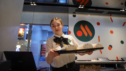 Russia McDonald's employee holding tray with food.