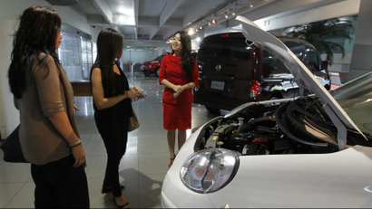 A saleswoman talks to customers at a Nissan dealership in Jakarta, Indonesia.