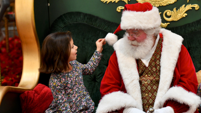 A child meets Santa Claus at a store grotto