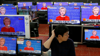A sales assistant watches the TV broadcast of the first presidential debate between U.S. Democratic presidential candidate Hillary Clinton and Republican presidential nominee Donald Trump, in Seoul, South Korea, September 27, 2016.