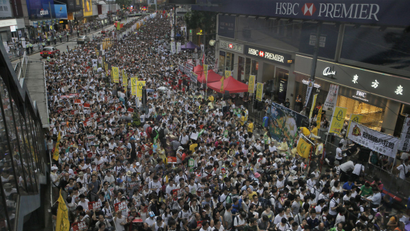 Tens of thousands of people fill in a street during a march at an annual protest in downtown Hong Kong Tuesday, July 1, 2014. Hong Kong residents marched through the streets of the former British colony to push for greater democracy in a rally fueled by anger over Beijing's recent warning that it holds the ultimate authority over the southern Chinese financial center. The protest comes days after nearly 800,000 residents voted in a mock referendum aimed at bolstering support for full democracy. (AP Photo/Vincent Yu