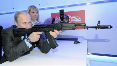Vladimir Putin aims at a target with a replica of the AK-47 assault rifle in a shooting gallery while attending an exhibition of Russian Railways' research center in Moscow on April 26, 2012.