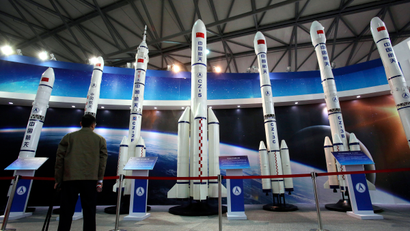 A visitor looks at the scale models of Chinese space rockets displayed at the China International Industry Fair in Shanghai, China, Tuesday, Nov. 5, 2013.