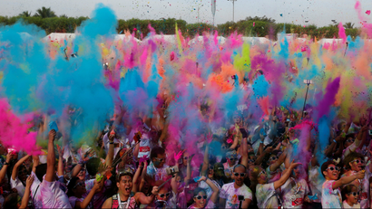 People throw in the air different colored powders as they celebrate