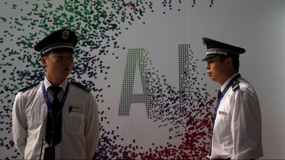 Security officers keep watch in front of an AI (Artificial Intelligence) sign at the annual Huawei Connect event in Shanghai, China September 18, 2019.