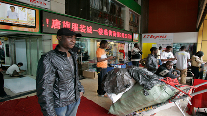An African man stands near a shopping mall in the southern Chinese city of Guangzhou in Guangdong province March 27, 2009. In the past few years, tens of thousands of African and Arab traders have thronged to export hubs like Guangzhou and Yiwu to seek their fortunes, sourcing cheap China-made goods back home to massive markups in a growing, lucrative trade. Picture taken March 27, 2009. To match feature FRICTION-CHINA/AFRICANS REUTERS/James Pomfret (CHINA POLITICS BUSINESS) - RTR26Y9O