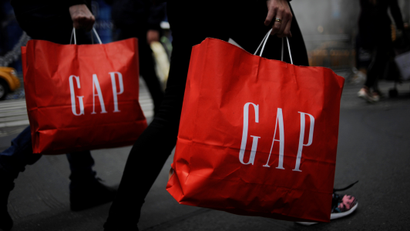Shoppers carry bags from a Gap store as they walk along Fifth Avenue in the Manhattan borough of New York, U.S., November 20, 2016. REUTERS/Mark Kauzlarich