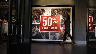 A woman walks by a discount sign at an Abercrombie & Fitch store at a shopping mall in Garden City, New York, U.S. on November 28, 2014. REUTERS/Shannon Stapleton/File Photo