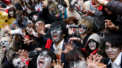 People, dressed as zombies, pose for photos after the Roppongi Zombie Walk in Tokyo March 31, 2013. About 50 people dressed up as zombies early evening on Sunday, catching the attention of pedestrians on the streets of Tokyo's downtown Roppongi district.