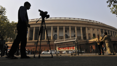 Television journalists report from the premises of India's Parliament in New Delhi