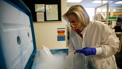 A pharmacist opens a freezer filled with dry ice.
