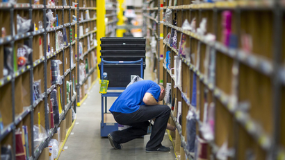 A worker puts together orders at the Amazon logistics center in Brieselang.