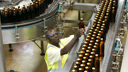 A worker inspects beer bottles on a conveyor belt of a factory in Nairobi, Kenya.