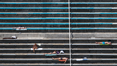 People sunbathe during warm weather on the spectators' ranks at a swimming pool area in Prague, Czech Republic, 31 July 2018.