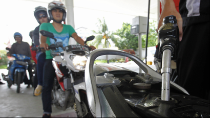An employee of state-owned Pertamina refuels a motorcycle at its petrol station in Jakarta, December 17, 2014.