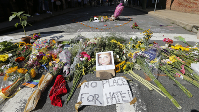 A makeshift memorial of flowers and a photo of victim, Heather Heyer, sits in Charlottesville, Va.,