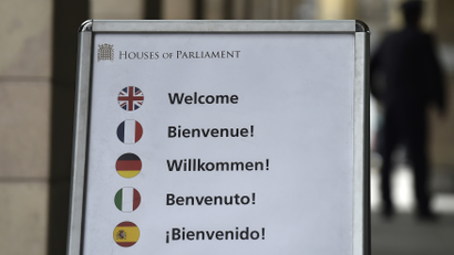 A board with various European language 'welcome' signage and national flag displays is seen outside of The Houses of Parliament in central London, Britain