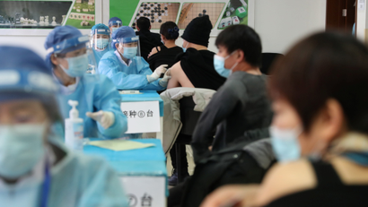 Medical workers administer COVID-19 vaccine at a makeshift vaccination site in Beijing