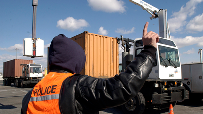 An officer from the United States Customs and Border Protection service inspect the contents of shipping containers with a truck mounted X-ray machine arriving at Port Newark from all around the world, in Newark, New Jersey February 24, 2006. Powerful Washington lawmakers citing security concerns are pushing emergency legislation to block a controversial deal that would place management of six major U.S. ports in the hands of a state-owned Arab company.