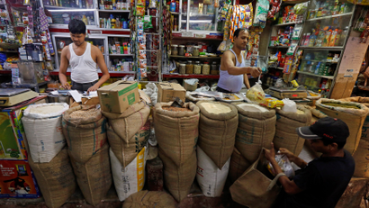 A shopkeeper sells groceries to a customer at his shop in Kolkata