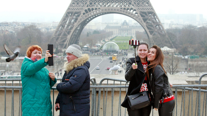 Tourists use a selfie stick on the Trocadero Square, with the Eiffel Tower in background, in Paris, Tuesday, Jan. 6, 2015. Selfie sticks have become enormously popular among tourists because you don’t have to ask strangers to take your picture, and unlike hand-held selfies, you can capture a wider view without showing your arm. But some people find selfie sticks obnoxious, arguing that they detract from the travel experience. (AP Photo/Remy de la Mauviniere)