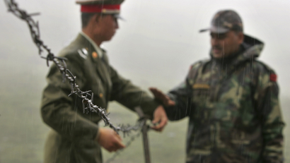 FILE - In this July 5, 2006 file photo, a Chinese soldier, left, and an Indian soldier put into place a barbed wire fence removed temporarily for Chinese officials to cross back to their country after a meeting with their Indian counterparts at the international border at Nathula Pass, in northeastern Indian state of Sikkim. While the recent troop standoff in a remote Himalayan desert spotlights a long-running border dispute between China and India, the two emerging giants are engaged in a rivalry for global influence that spreads much farther afield.