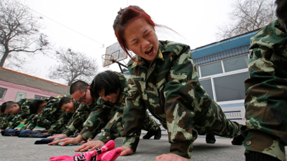 Students receive a group punishment during a military-style close-order drill class at the Qide Education Center in Beijing February 19, 2014. The Qide Education Center is a military-style boot camp which offers treatment for internet addiction. As growing numbers of young people in China immerse themselves in the cyber world, spending hours playing games online, worried parents are increasingly turning to boot camps to crush addiction. Military-style boot camps, designed to wean young people off their addiction to the internet, number as many as 250 in China alone. Picture taken February 19, 2014. REUTERS/Kim Kyung-Hoon (CHINA - Tags: SOCIETY)