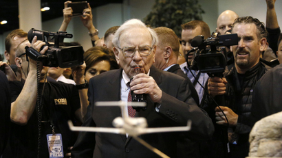 Berkshire Hathaway CEO Warren Buffett drinks Coca Cola at the BNSF display at a trade show, during the company's annual meeting in Omaha, Nebraska May 3, 2014. Warren Buffett's Berkshire Hathaway Inc on Friday said quarterly profit declined 4 percent, falling short of analyst forecasts, as earnings from insurance underwriting declined and bad weather disrupted shipping at its BNSF Railway unit. REUTERS/Rick Wilking(UNITED STATES - Tags: BUSINESS)