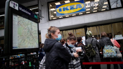 People, wearing protective face masks, queue outside the Swedish furniture giant IKEA store in Paris.