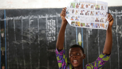An electoral officer holds up a ballot paper during the count of votes after polling stations closed for the presidential election in Cotonou, Benin March 6, 2016.