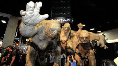 Fans walk past huge Stone Troll figures from the Lord of the Rings at the Comic-Con preview night held at the San Diego Convention Center on Wednesday July 11, 2012, in San Diego.
