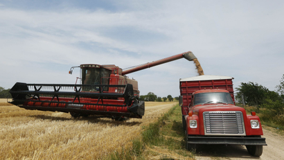 In this June 24, 2013 file photo, Lester Reimer harvests wheat on his farm near Lebo, Kan. Updated government estimates of the size of this year's crop is expected later today. (AP Photo/Orlin Wagner, File)