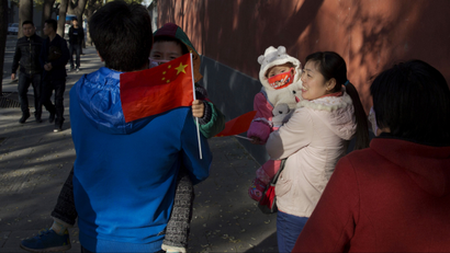 Visitors to the forbidden city, carry children holding the Chinese national flags in Beijing, China, Saturday, Nov. 16, 2013. Some 15 million to 20 million Chinese parents will be allowed to have a second baby after the Chinese government announced Friday, Nov. 15, 2013 that couples where one partner has no siblings can have two children, in the first significant easing of the country’s strict one-child policy in nearly three decades. (AP Photo/Ng Han Guan